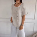 Blusa Amora™ de algodão leve com botões laterais, caimento solto e estilo natural, em tecido claro e toque confortável.