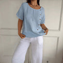 Blusa Amora™ em algodão leve com botões laterais, caimento solto, estilo natural, ideal para looks confortáveis e elegantes.