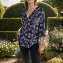 Camisa Maitê™ em viscose floral com bolso brilhante em strass, estilo elegante e delicado, ideal para looks femininos sofisticados.