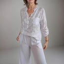 Camisa Maitê™ em viscose floral com bolso brilhante em strass, estilo elegante e delicado, para um look sofisticado e feminino.